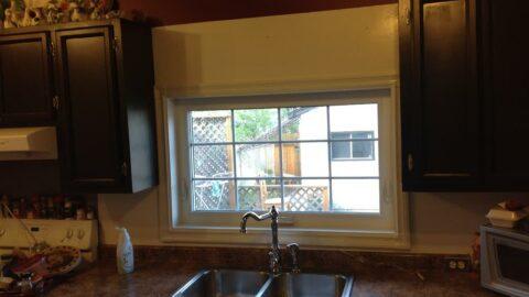 A kitchen window with cut casings to accomodate for cabinets