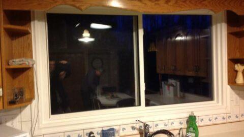 A kitchen slider window with cut casings to fit the cabinets