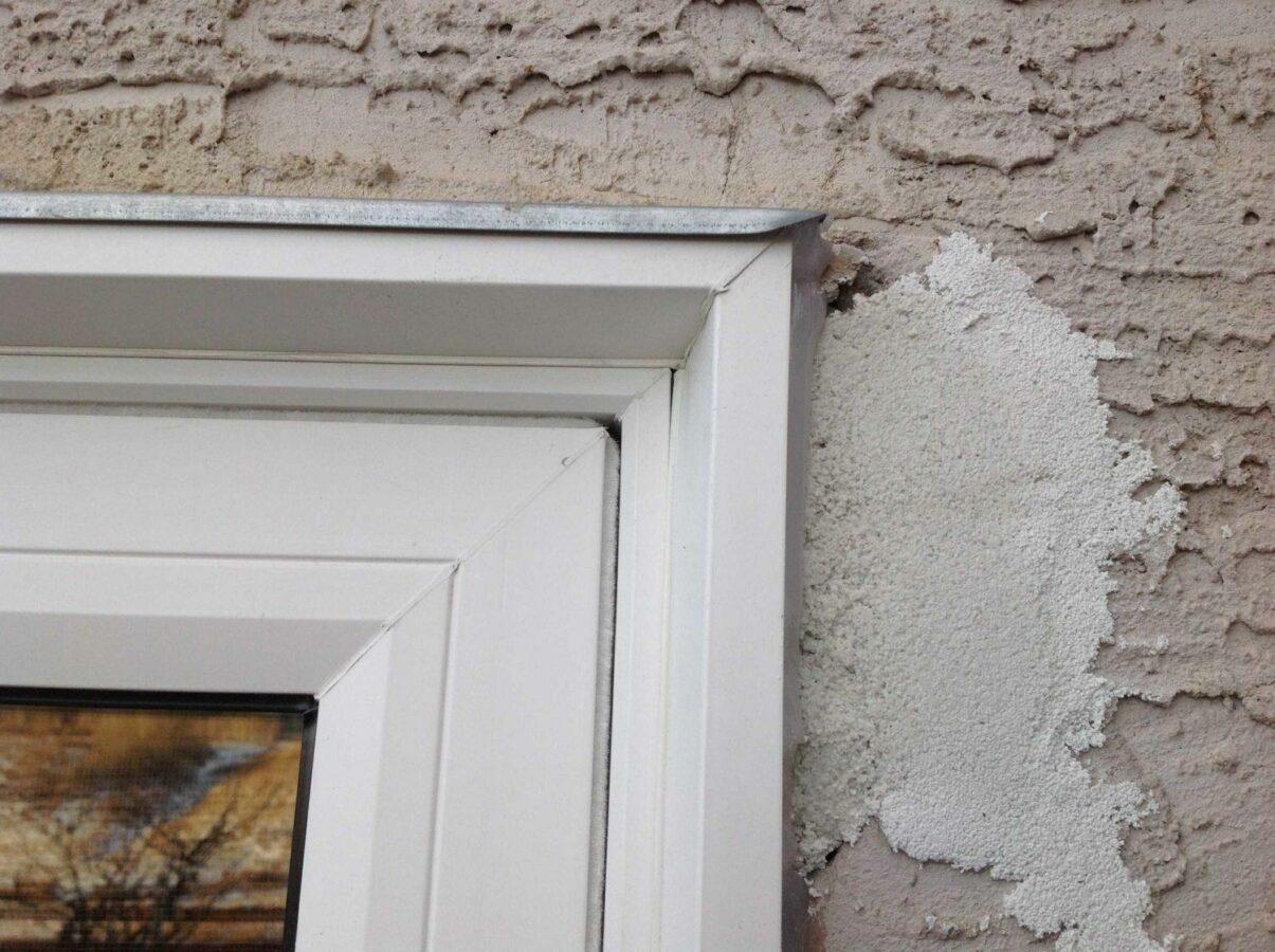 A replacement window with a stucco patch