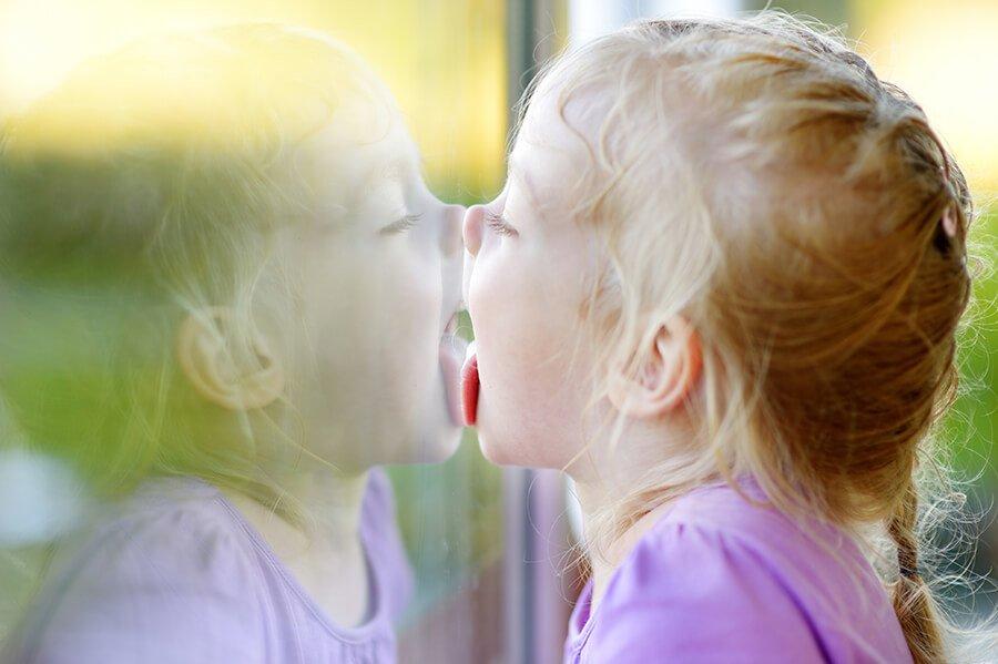 funny girl licking her window glass reflection