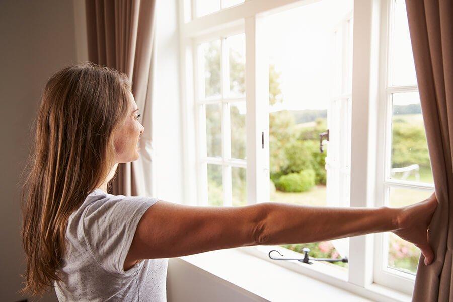 woman enjoys bedroom window view